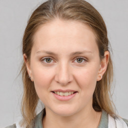 Joyful white young-adult female with medium  brown hair and grey eyes