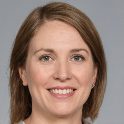 Joyful white adult female with medium  brown hair and grey eyes