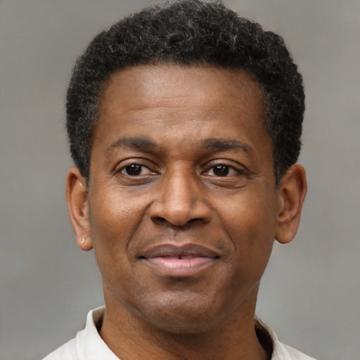 Joyful black young-adult male with short  brown hair and brown eyes