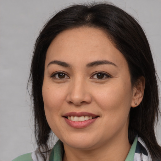 Joyful latino young-adult female with medium  brown hair and brown eyes
