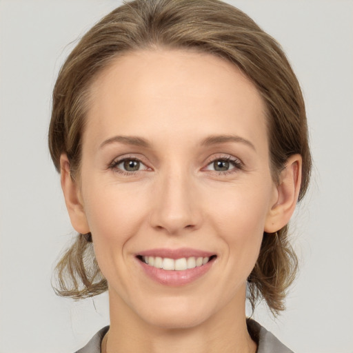 Joyful white young-adult female with medium  brown hair and grey eyes