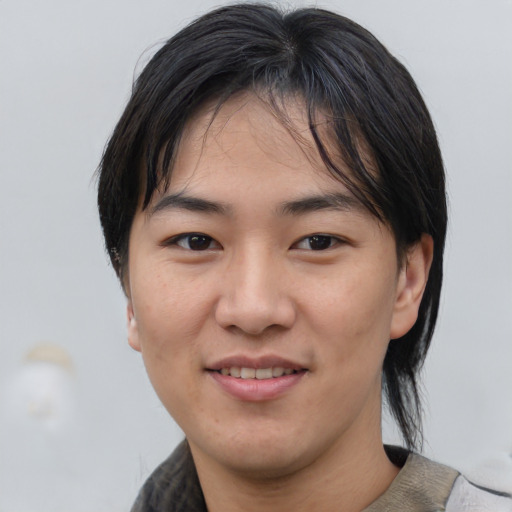 Joyful asian young-adult male with medium  brown hair and brown eyes