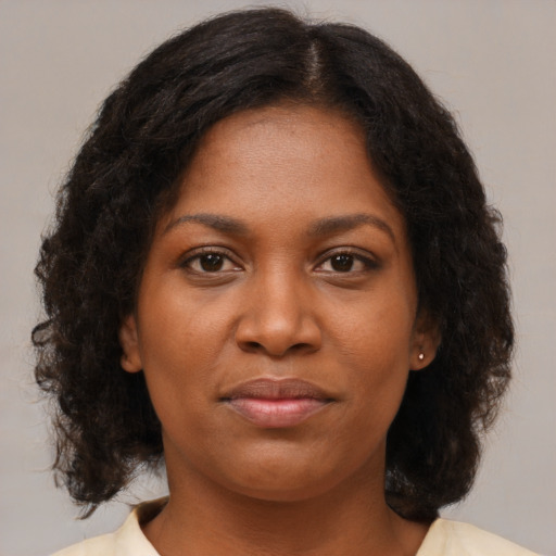 Joyful black young-adult female with medium  brown hair and brown eyes