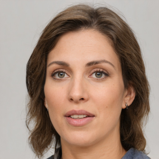 Joyful white young-adult female with medium  brown hair and green eyes