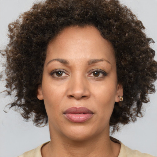 Joyful black adult female with medium  brown hair and brown eyes