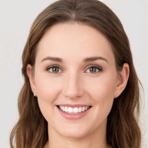 Joyful white young-adult female with long  brown hair and grey eyes