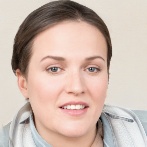 Joyful white young-adult female with short  brown hair and blue eyes