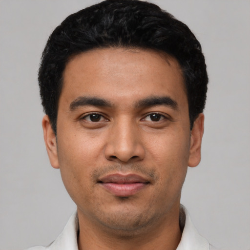 Joyful latino young-adult male with short  black hair and brown eyes