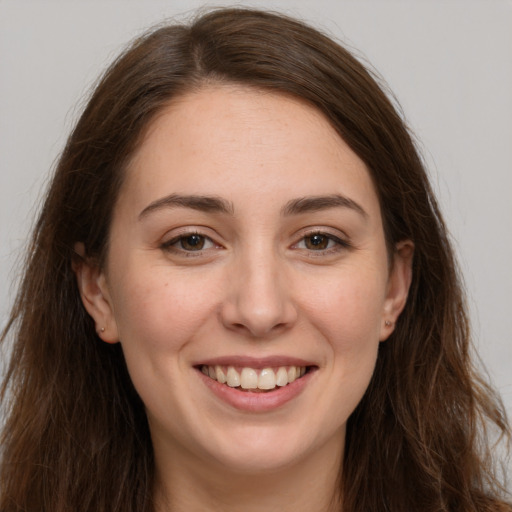 Joyful white young-adult female with long  brown hair and brown eyes