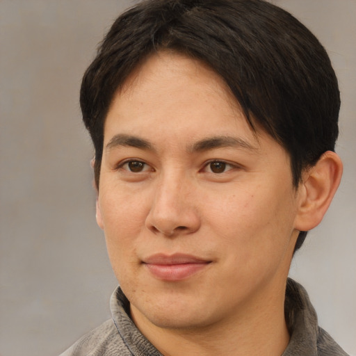 Joyful asian adult male with short  brown hair and brown eyes