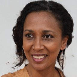 Joyful black adult female with medium  brown hair and brown eyes