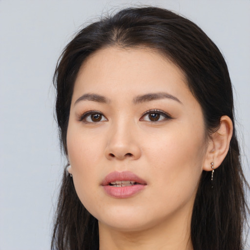 Joyful asian young-adult female with long  brown hair and brown eyes