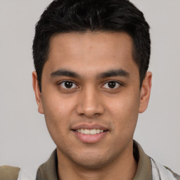 Joyful latino young-adult male with short  brown hair and brown eyes