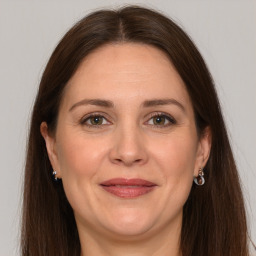 Joyful white adult female with long  brown hair and grey eyes