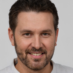 Joyful white adult male with short  brown hair and brown eyes