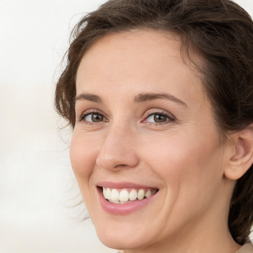 Joyful white young-adult female with medium  brown hair and green eyes