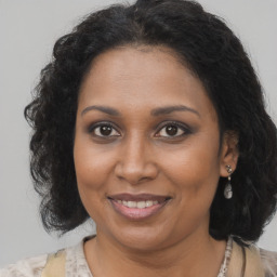 Joyful black adult female with medium  brown hair and brown eyes