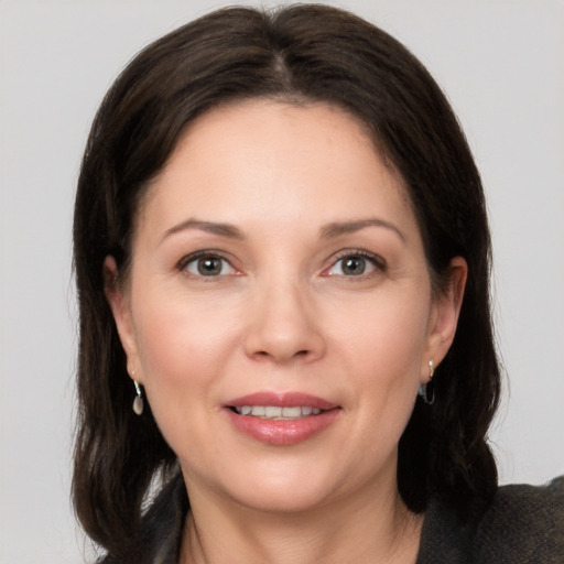 Joyful white adult female with medium  brown hair and brown eyes