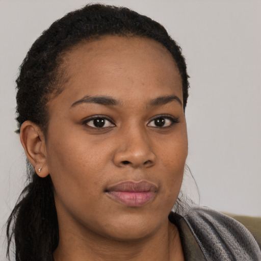 Joyful black young-adult female with long  brown hair and brown eyes