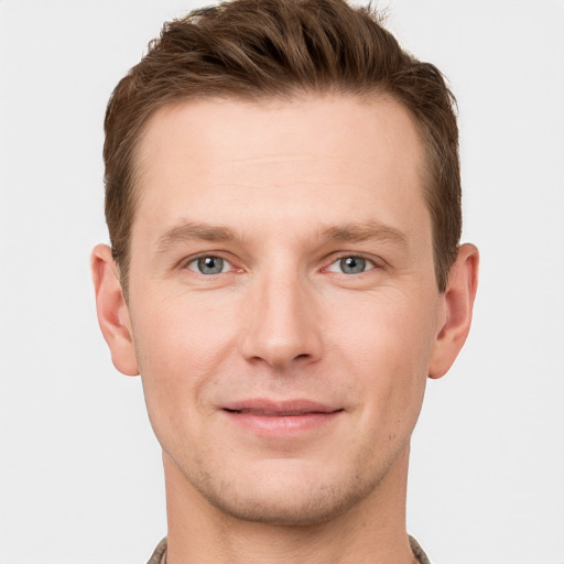 Joyful white young-adult male with short  brown hair and grey eyes