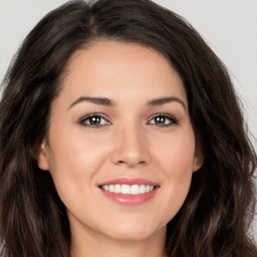 Joyful white young-adult female with long  brown hair and brown eyes