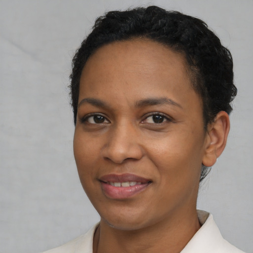 Joyful black young-adult female with short  black hair and brown eyes