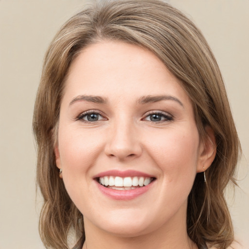 Joyful white young-adult female with medium  brown hair and green eyes