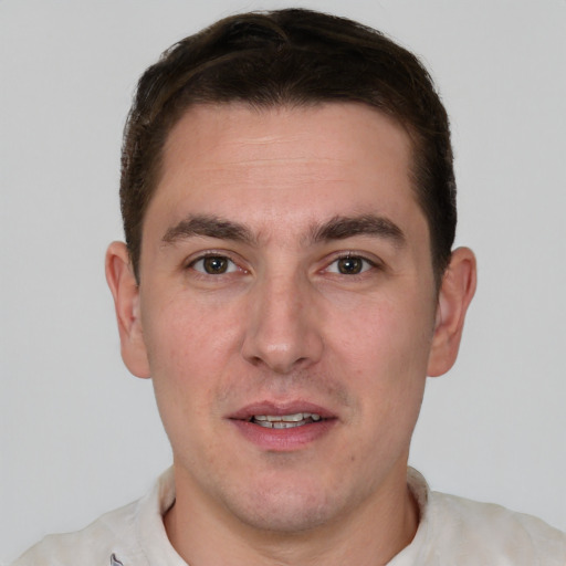 Joyful white young-adult male with short  brown hair and brown eyes