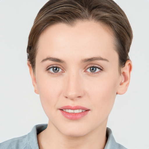 Joyful white young-adult female with short  brown hair and grey eyes