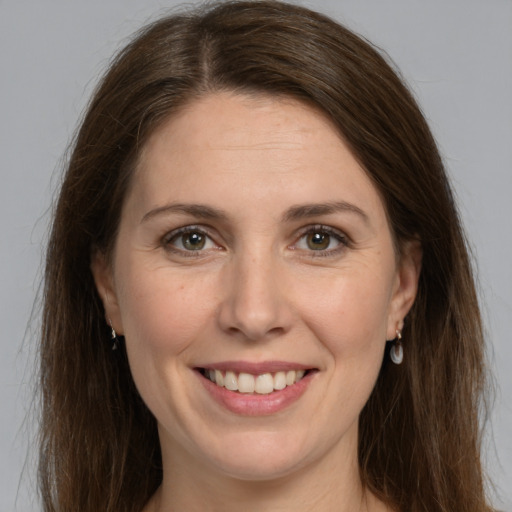 Joyful white adult female with long  brown hair and grey eyes