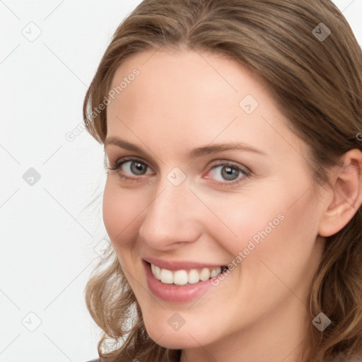 Joyful white young-adult female with long  brown hair and blue eyes