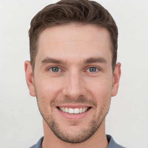 Joyful white young-adult male with short  brown hair and grey eyes