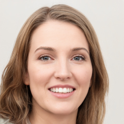 Joyful white young-adult female with long  brown hair and green eyes