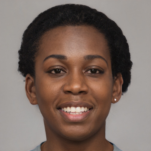 Joyful black young-adult female with short  black hair and brown eyes