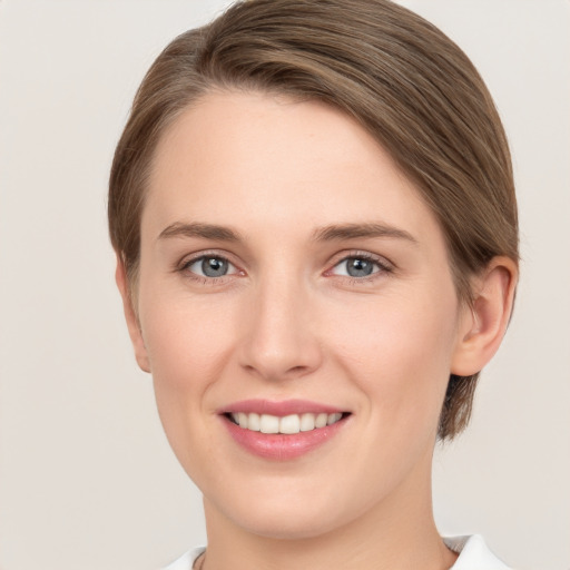 Joyful white young-adult female with short  brown hair and grey eyes