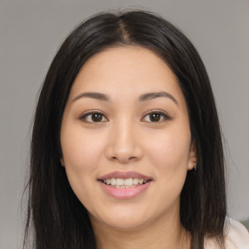 Joyful asian young-adult female with long  brown hair and brown eyes