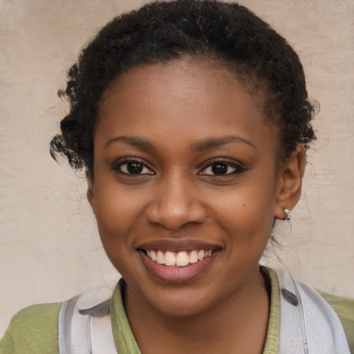 Joyful black young-adult female with short  brown hair and brown eyes