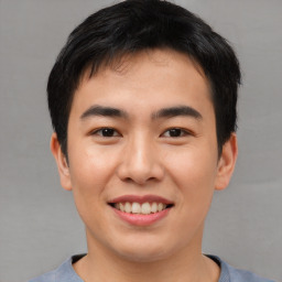 Joyful asian young-adult male with short  black hair and brown eyes