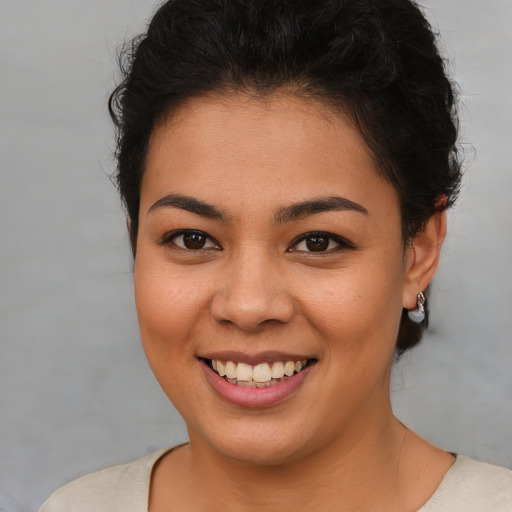 Joyful latino young-adult female with short  brown hair and brown eyes