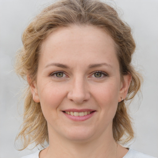 Joyful white young-adult female with medium  brown hair and blue eyes