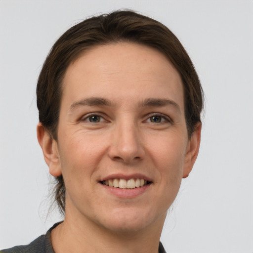 Joyful white young-adult female with short  brown hair and grey eyes