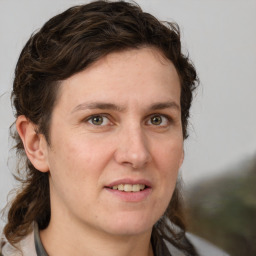 Joyful white adult female with medium  brown hair and grey eyes