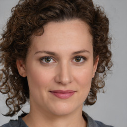 Joyful white young-adult female with medium  brown hair and green eyes