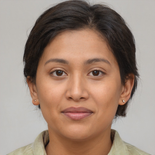 Joyful latino young-adult female with medium  brown hair and brown eyes