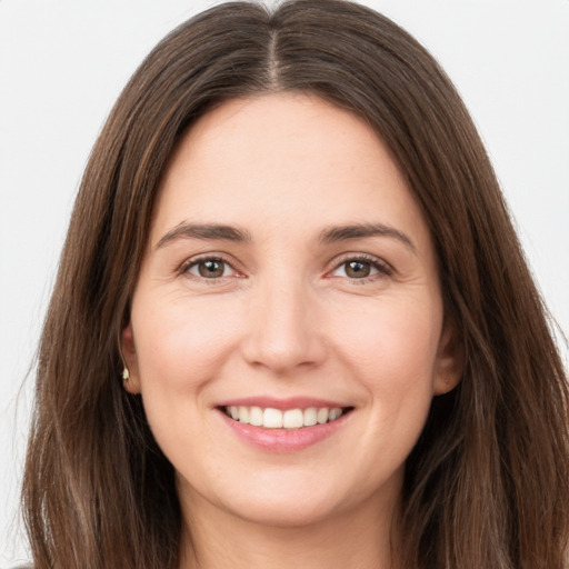 Joyful white young-adult female with long  brown hair and brown eyes