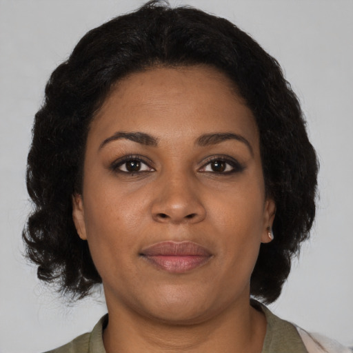 Joyful black adult female with medium  brown hair and brown eyes
