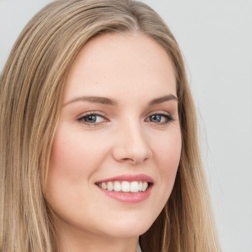 Joyful white young-adult female with long  brown hair and green eyes