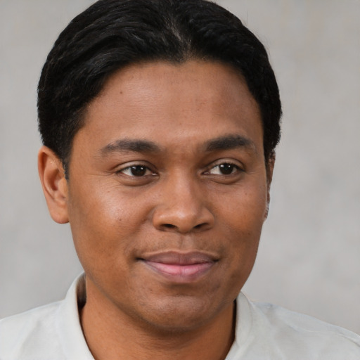 Joyful latino young-adult male with short  brown hair and brown eyes