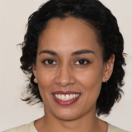 Joyful black young-adult female with medium  brown hair and brown eyes