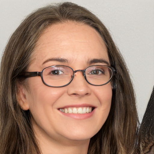 Joyful white adult female with long  brown hair and brown eyes